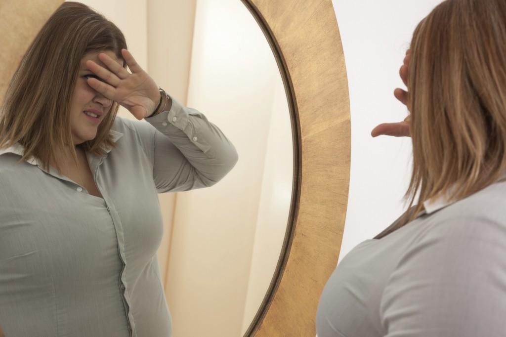 woman rejecting her self-image in the mirror.